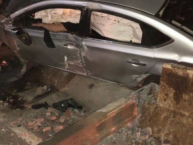 Em virtude da colisão forte, o carro ficou engatado na mureta e destruiu também um poste da rede de iluminação (Foto: Reprodução Rondoniaovivo)